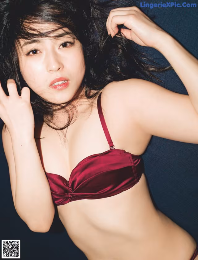 A woman in a red bra and panties posing for a picture.