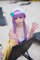 A woman with purple hair sitting in a chair on the beach.