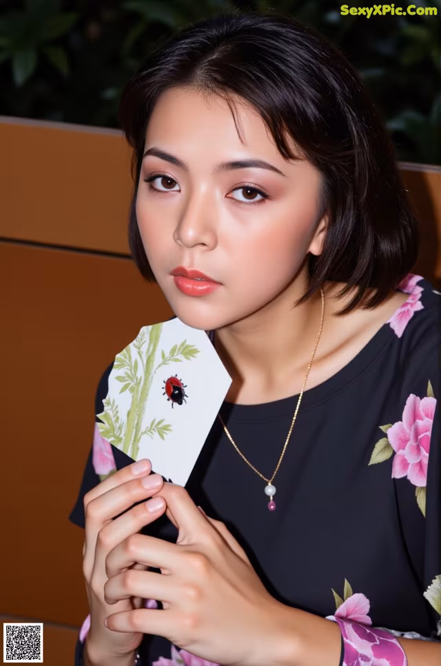 A woman holding a card with a ladybug on it.