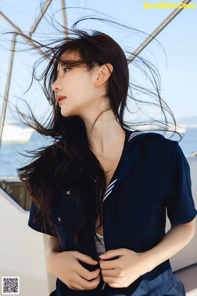 A woman in a sailor outfit standing on a boat.