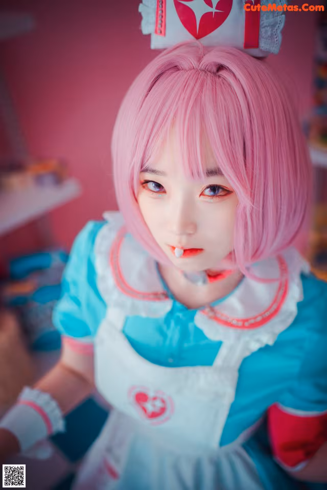 A woman with pink hair wearing a blue and white dress.