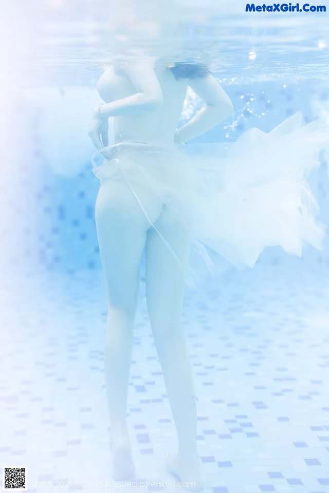 A woman in a white dress is standing in the water.