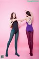 Two young women in leotards are posing for a picture.