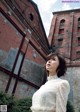 A woman standing in front of an old brick building.