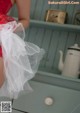 A woman in a red and white lingerie standing on a dresser.