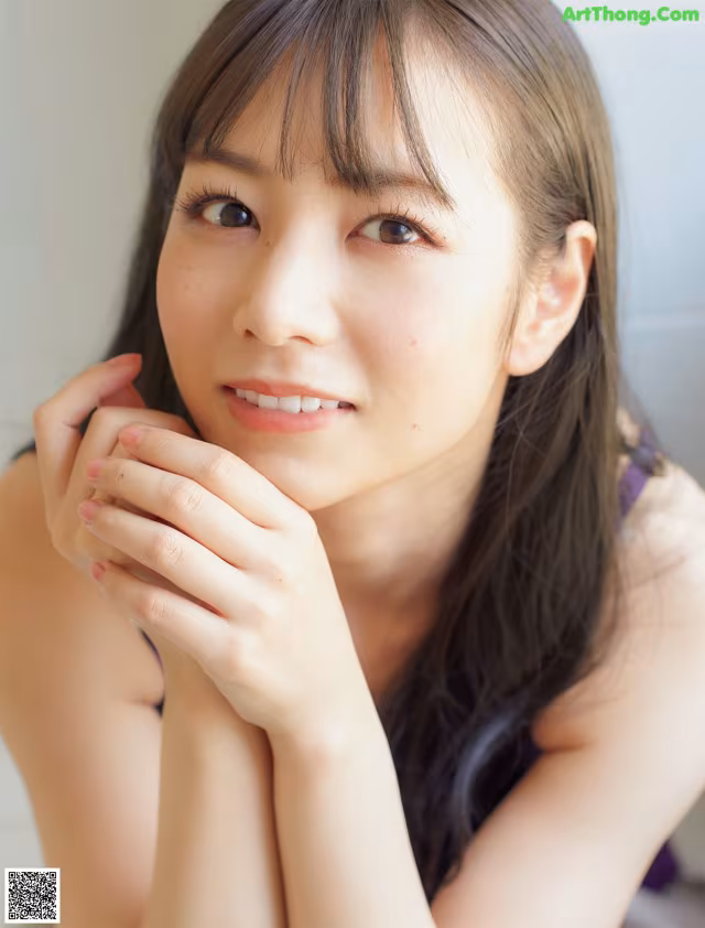 A woman with long brown hair is posing for a picture.