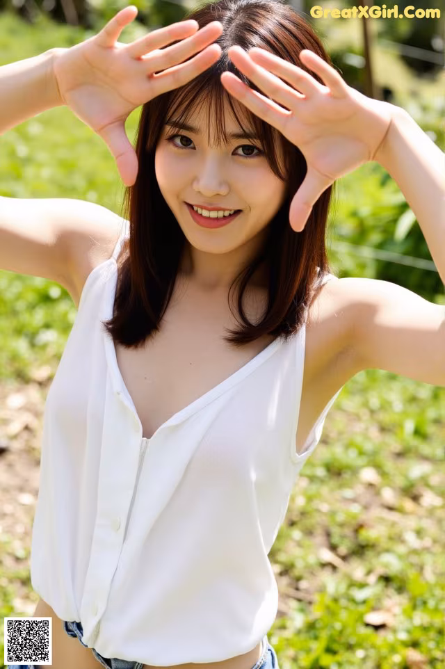 A woman in a white shirt and denim shorts posing for a picture.