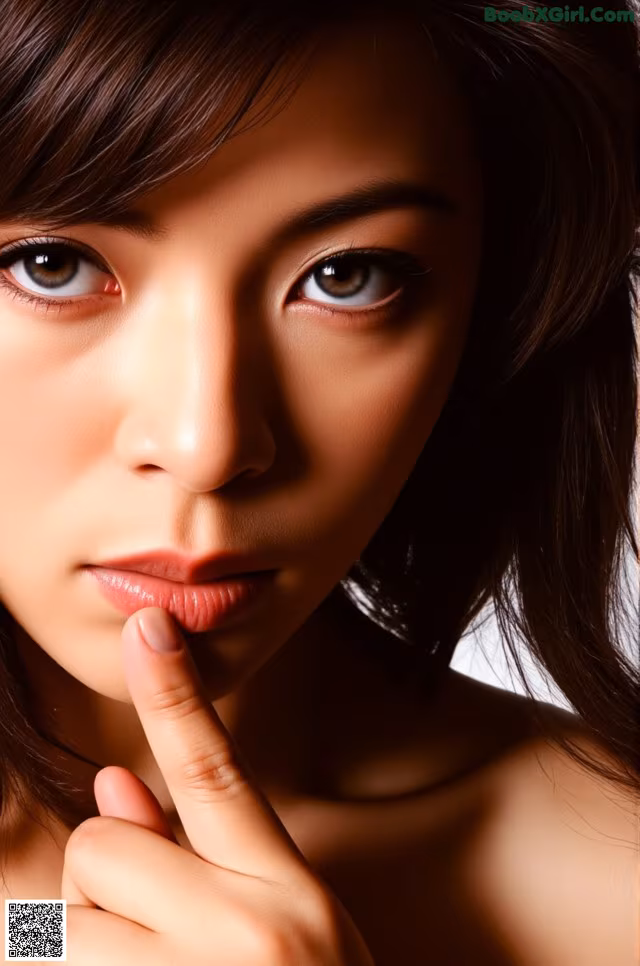 A close up of a woman with her finger on her lips.